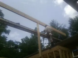Carpenter setting a ridge beam over a new addition frame — Ice Dam Removal by Roofing Brothers in Brunson