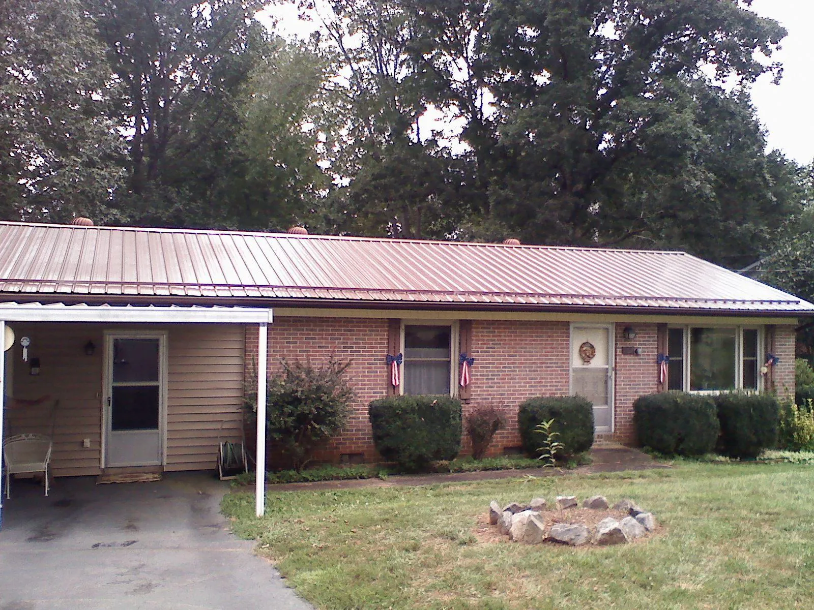 Bronze metal roof and carport on a brick ranch home — Roof Repair work by our crew in Brunson