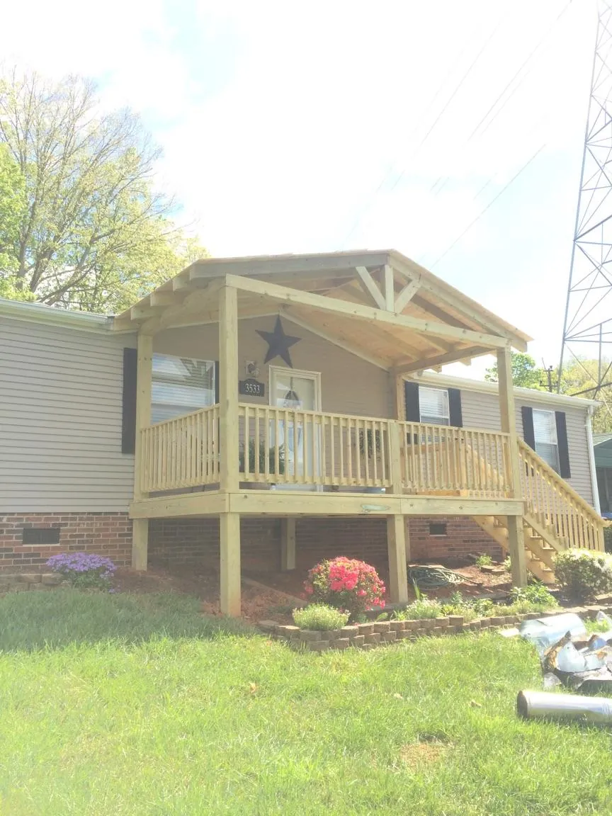 New gabled porch roof and deck railing added to a ranch home in Brunson